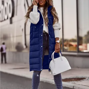 Gilet lungo imbottito blu scuro senza maniche da donna con borsa bianca in ambiente urbano