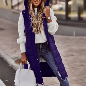 Dettaglio di un lungo gilet imbottito blu scuro con cappuccio e maglione bianco.