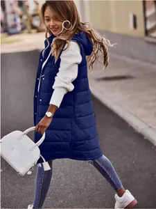 Gilet lungo imbottito blu navy con cappuccio da donna in un elegante contesto urbano
