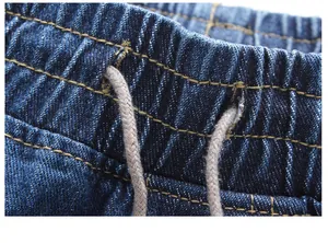 Nahaufnahme des elastischen Bunds mit Kordelzug an einer blauen Herren-Denim-Joggerhose.