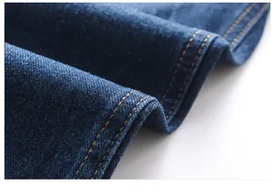 Nahaufnahme der dunkelblauen Denim-Stofftextur und gelber Doppelnaht-Details.