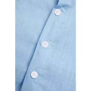 Close-up of light blue linen cotton men's casual beach shirt fabric and buttons