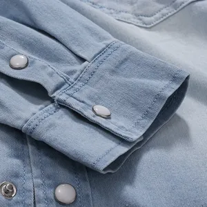 Primer plano del puño de una camisa vaquera azul claro con botones blancos de nácar