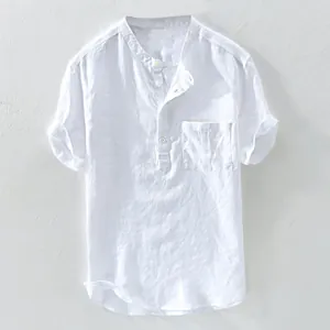 Detailed view of white short-sleeved linen shirt featuring band collar and chest pocket