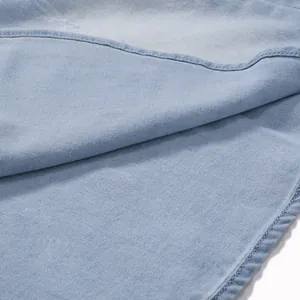 Primer plano de la textura de la tela vaquera azul claro y costuras de camisa