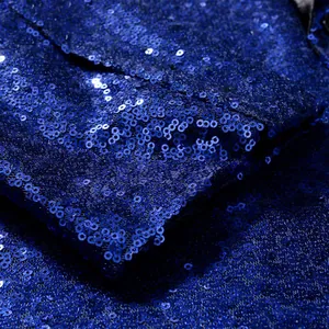 Macro detail showing the shimmering royal blue sequins on a performance suit jacket.