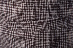 Macro close-up detail of brown houndstooth fabric and pocket on a men's stylish vest