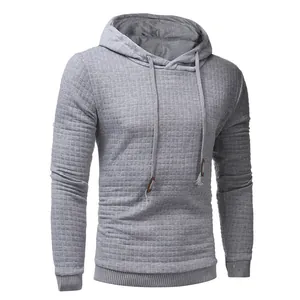 Detail view of light grey men's hoodie with quilted diamond texture and drawstring.