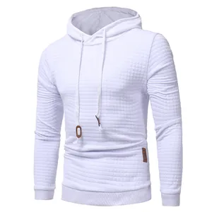 Detailed view of men's white hoodie featuring a textured diamond pattern and drawstring hood