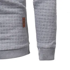 Close-up detail of gray quilted texture and ribbed cuff on a men's sweatshirt