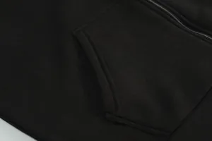 Detaillierte Makroansicht der Tasche und des Reißverschlusses einer schwarzen Kapuzenweste