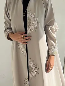 Detail view of sunflower embroidery and pearled beading on a grey long cardigan robe