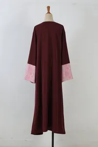 Elegant dark burgundy long-sleeved robe with pink patterned cuffs, mannequin back view.