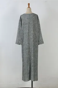 Back view detail of an elegant olive green maxi dress with delicate floral branch prints.