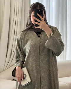 Elegant olive green long dress with delicate branching patterns shown on a model in detail