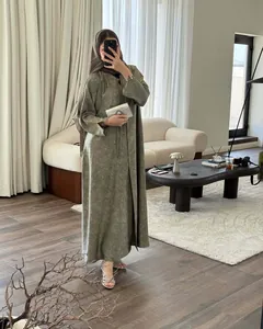 Elegant olive green floral pattern Abaya dress with matching hijab in a luxury living room
