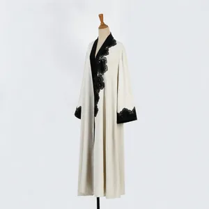 Detail view of cream long robe with black floral lace embroidery on mannequin
