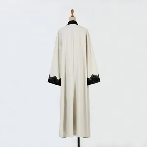 Back view of a long cream cardigan with black lace embroidered cuffs on a mannequin