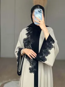 Close-up detail of intricate black floral lace embroidery on a beige long cardigan abaya coat.