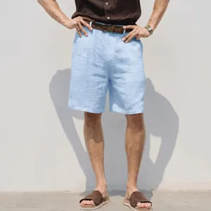Detailed shot of men's light blue linen shorts styled with a brown belt and sandals