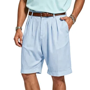 Detail view of men's light blue pleated linen shorts with a classic brown leather belt.