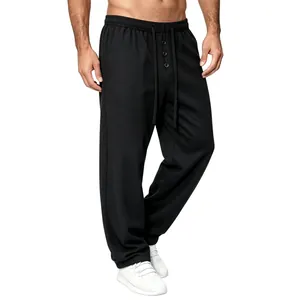 Macro view of men's black waffle knit lounge pants with drawstring and button detail
