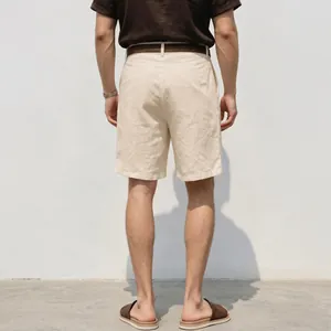 Back view of men's loose beige linen shorts featuring breathable natural fabric texture