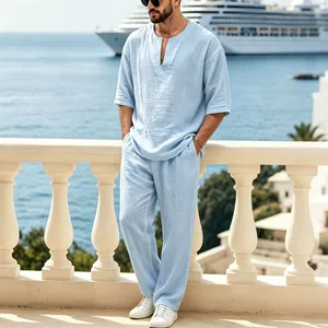 Completo due pezzi in lino azzurro da uomo con top scollo a V e pantaloni dritti larghi.