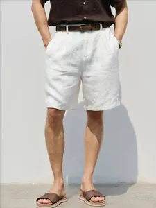 Men's loose white breathable linen casual shorts styled with a brown belt and shirt
