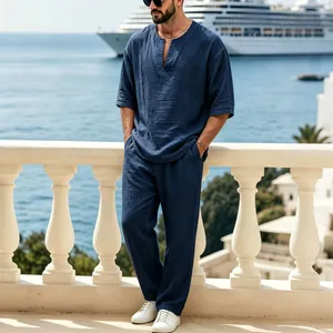 Completo uomo in lino blu navy con maglia scollo a V e pantaloni larghi per l'estate.