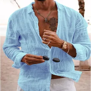 Detail shot of a light blue long-sleeved linen beach shirt for men in a coastal setting.