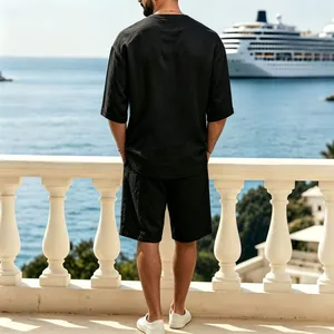 Vista trasera de conjunto de lino negro para hombre en un balcón frente al mar
