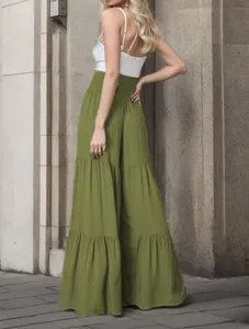 Dettaglio laterale dei pantaloni larghi verde oliva a balze con vita alta a punto smock