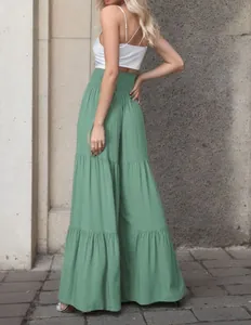 Vista laterale dei pantaloni larghi a balze verde salvia da donna a vita alta.
