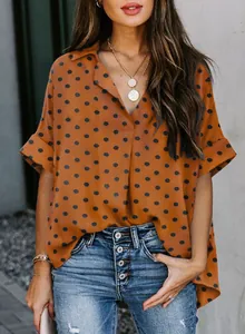Macro view of women's burnt orange polka dot V-neck Polo shirt showing fabric detail