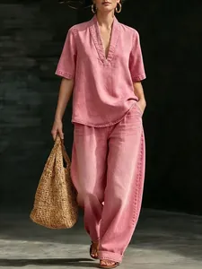 Vista completa de una modelo con un top rosa con cuello en V y pantalones anchos