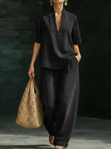 Vista completa de top negro con cuello en V y pantalones anchos con bolso de paja