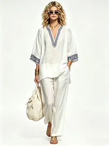 Elegant woman wearing a bohemian ivory linen V-neck printed top and matching pants