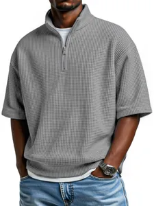 Détail d'un polo gris en maille gaufrée pour homme avec demi-fermeture éclair et manches courtes