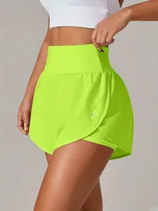 Dettaglio degli shorts sportivi 2-in-1 verde neon a vita alta con punti riflettenti.