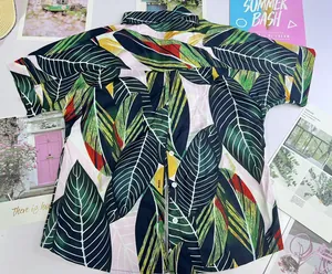 Detailed flat lay of women's vibrant tropical leaf print V-neck Polo shirt with short sleeves