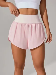 Primo piano di pantaloncini sportivi rosa a vita alta a doppio strato da donna per il fitness