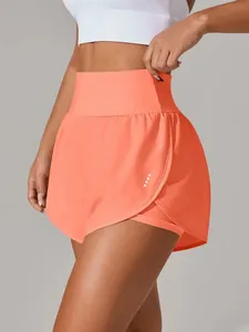 Dettaglio laterale di pantaloncini da yoga corallo a vita alta con design due in uno