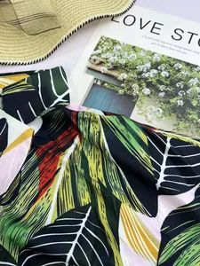 Close-up detail of a women's tropical leaf print V-neck Polo shirt in summer colors.