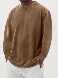 Detail van een vintage gewassen bruin katoenen T-shirt met lange mouwen en ronde hals