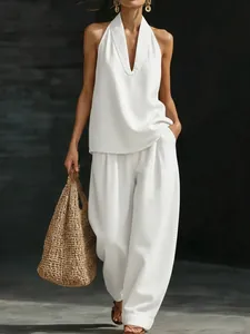 Vue complète d'un ensemble haut dos nu en denim blanc et pantalon large avec sac tressé
