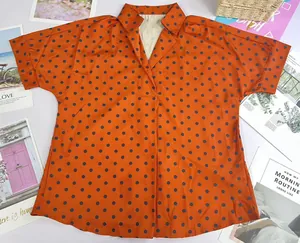 Close-up of orange polka dot printed V-neck polo shirt with chic half sleeves design