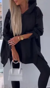 Close-up of black oversized hoodie with side slits and matching leggings set