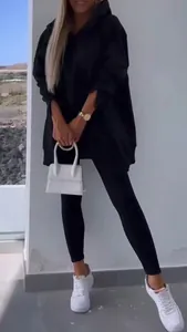 Full-body detail showing the fit of the black two-piece hoodie and leggings tracksuit set