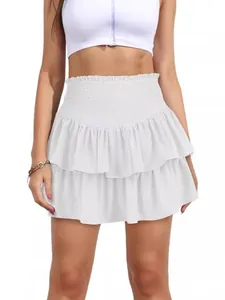 Elegant white bohemian tiered tennis skirt featuring a high smocked waist and ruffles